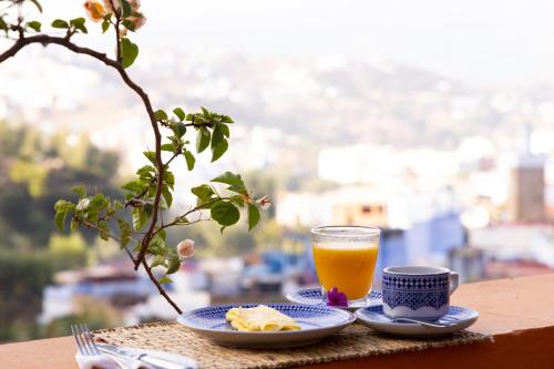 un plato de comida y un vaso de jugo de naranja en Dar Rass El Maa, en Chefchaouen