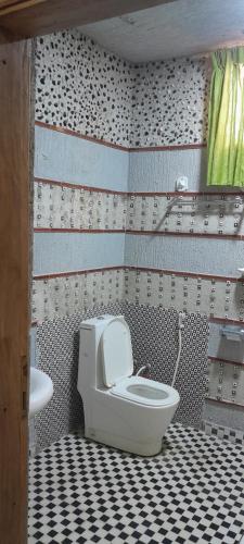 a bathroom with a toilet and a black and white tiled floor at Ashara guesthouse in Āwasa