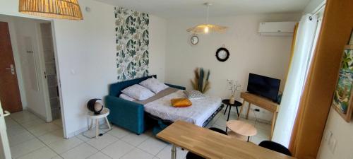 un salon avec un canapé bleu et une télévision dans l'établissement Ti DODO studio cosy avec 2 piscines, à Saint-Pierre