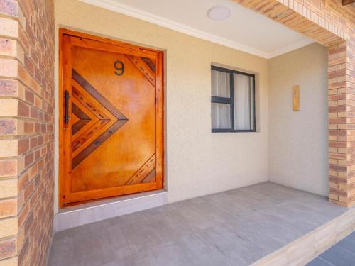 a wooden door in a room with a brick wall at Kuhle Guesthouse in Kempton Park