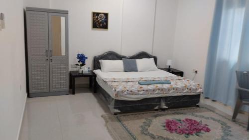 a bedroom with a bed and a door and a rug at Bait Alhoor in Muscat