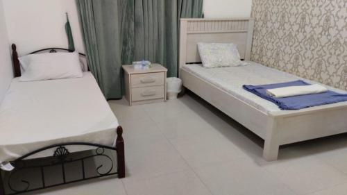 a bedroom with two beds and a night stand at Bait Alhoor in Muscat