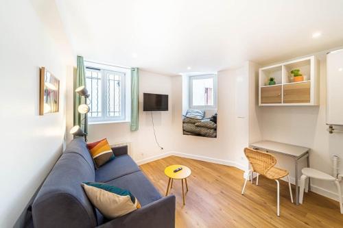 Una sala de estar con un sofá azul y una mesa. en Quiet & Comfortable Studio Near Lyon Sainte-Foy-lès-Lyon, en Sainte-Foy-lès-Lyon