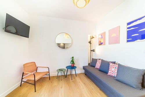 Una sala de estar con un sofá azul y una mesa. en Le Pablo charming 6 pers Sainte-Foy-lès-Lyon, en Sainte-Foy-lès-Lyon