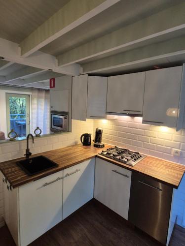 a kitchen with white cabinets and a stove top oven at Bois d' Paix in Durbuy