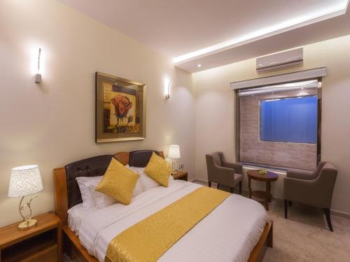 1 dormitorio con cama, escritorio y ventana en Aliah Apartment, en Khamis Mushayt