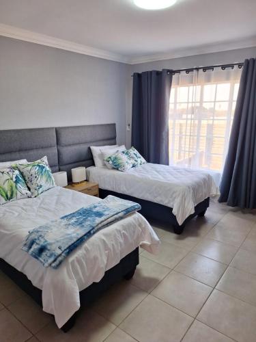 a bedroom with two beds and a window at 310 Bonnyvale in Kempton Park
