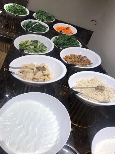 Una mesa llena de tazones de comida sobre un mostrador. en فندق هيل Hill Hotel, en Medina