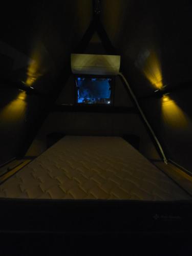 an attic room with a bed and a window at Cabana Fé Miguel Pereira Com Ofuro e Por do Sol in Miguel Pereira