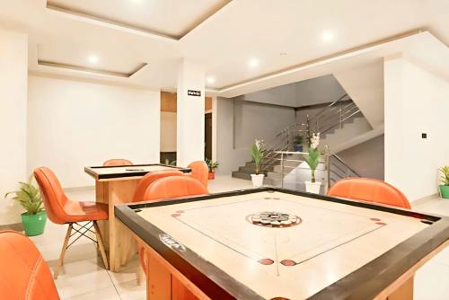 Un comedor con una mesa de ping pong y sillas naranjas. en Blissofhaven, en Haripūr