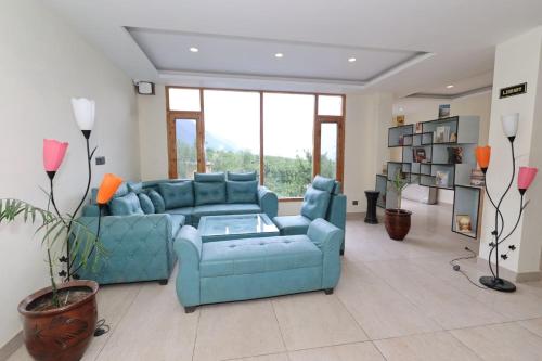 Una sala de estar con un sofá azul y una mesa. en Blissofhaven, en Haripūr