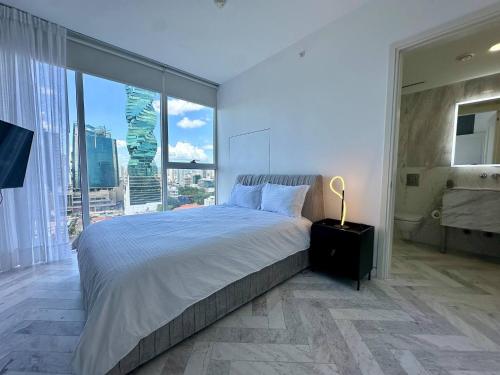a bedroom with a large bed and a large window at Luxury apt in Panama City 2 Rooms 3 Baths office in Panama City