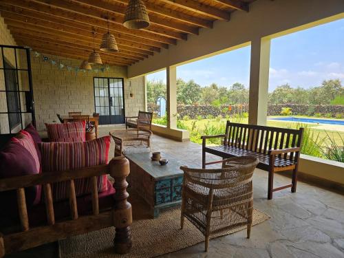 a living room with chairs and a couch and a table at Kipepeo Villa in Naivasha