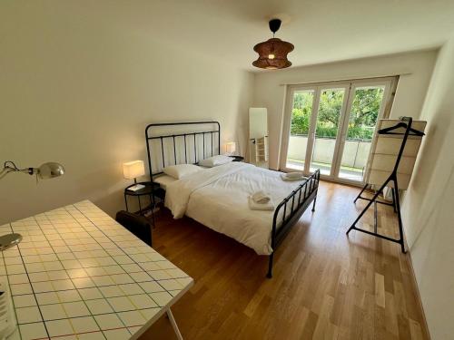 una camera da letto con un letto, un tavolo e una finestra di Basic & Comfy on Langgrütstrasse a Zurigo