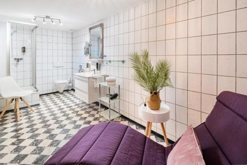 a bathroom with a purple couch and a sink at Hotel Nürnberger Hof in Altdorf in Altdorf bei Nuernberg