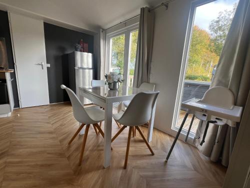 a kitchen with a table and chairs and a refrigerator at 6-Pers chalet Lauwersoog in Lauwersoog