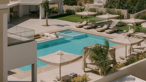 an overhead view of a swimming pool with umbrellas at Anassa Villa, with 110m2 Pool, Emerald Gardens, Wellness & Sports, By ThinkVilla 
