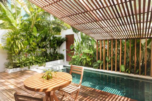 a wooden table and chairs next to a swimming pool at Manao Villas in General Luna