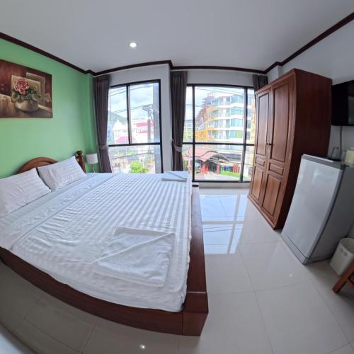 a bedroom with a large bed and two windows at Hotel premier in Patong Beach
