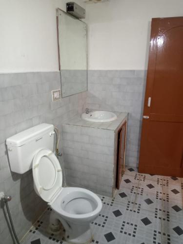a bathroom with a toilet and a sink at Kodai ARYASREE in Kodaikānāl