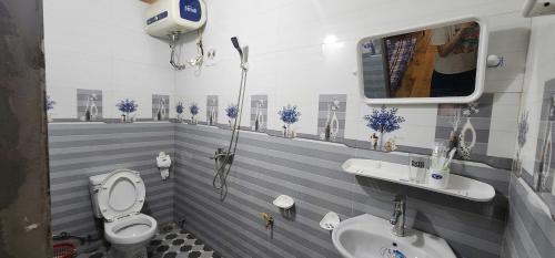a bathroom with a white toilet and a sink at Trạm Thẩm Lé in Văn Chấn