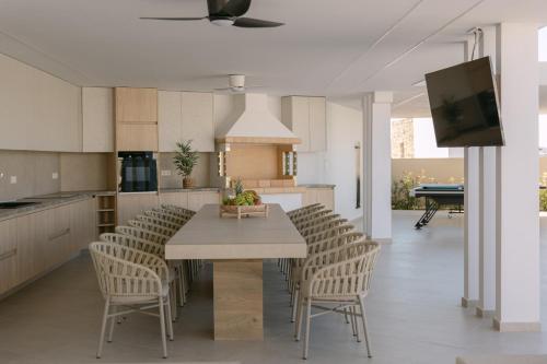 a kitchen and dining room with a table and chairs at Anassa Villa, with 110m2 Pool, Emerald Gardens, Wellness & Sports, By ThinkVilla 