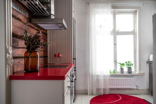 a kitchen with a red counter and a window at Hirsihuvi 1826 in Oulu
