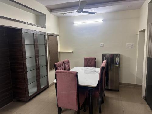 een kamer met een tafel en stoelen en een koelkast bij Sita stays in Vijayawāda