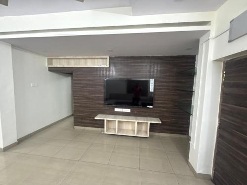 een woonkamer met een tv aan de muur bij Sita stays in Vijayawāda