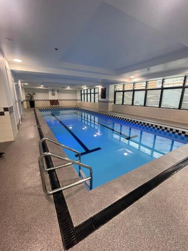 a large swimming pool with blue water in a building at Entire Apartment 21st Floor Queen Street in Auckland