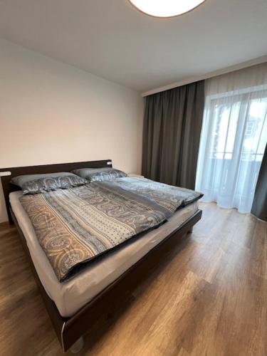 1 dormitorio con 1 cama y suelo de madera en Ferienwohnung Romy, en Absam