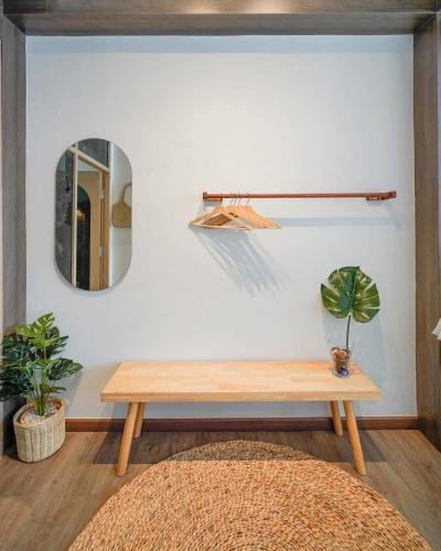 a room with a wooden table and a mirror at Krung Boutique Hotel in Bangkok