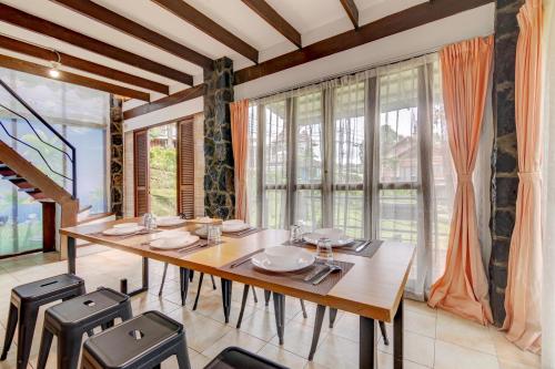 万隆Villa Pinokio W BBQ & Backyard的一间有桌椅和窗户的餐厅