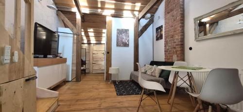 a room with a table and chairs and a television at Staszica Starówka in Olsztyn
