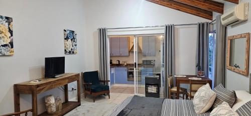 una sala de estar con escritorio y una habitación con cocina en Fair View, en Somerset West