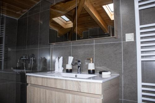 une salle de bain avec un lavabo et un miroir dans l'établissement Snow Chalets Parnassos, à Kalívia