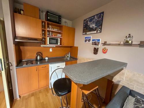 - une petite cuisine avec un comptoir et une table dans l'établissement Apartmán v Srdci hor - Říčky v Orlických horách, à Říčky