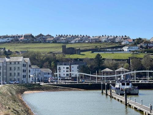 Ein Boot liegt an einem Dock auf einem Fluss. in der Unterkunft Lovely 2BED Whitehaven Apartment with Sea Views in Whitehaven