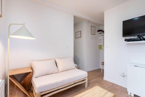 a living room with a white couch and a tv at Apartment Perron - Cozy 2 people - Oullins in Oullins