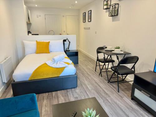 Un dormitorio con una cama y una mesa y sillas. en Seaside Escape - Central Studio Near Beach and Town, en Bournemouth