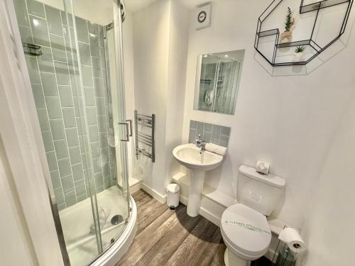 Un baño con inodoro, lavabo y ducha. en Seaside Escape - Central Studio Near Beach and Town, en Bournemouth