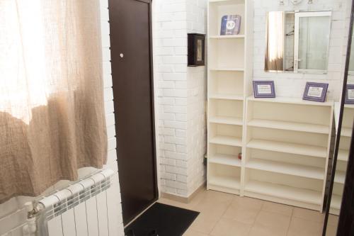 オムスクにあるApartment Shukshinaのバスルーム(白い棚、鏡付)