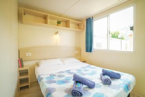 a bedroom with a bed with towels on it at Happy Camp mobile homes in Camping Village Free Time in Marina di Bibbona