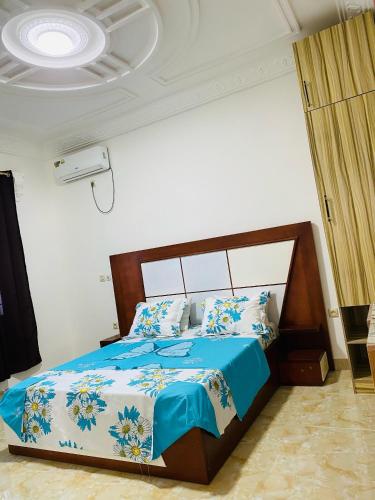 a bedroom with a bed with a blue comforter at Seaside Lodging in Limbe