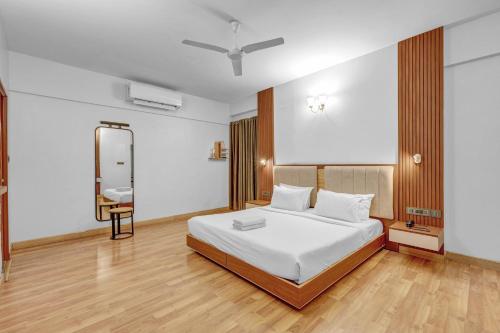 a bedroom with a white bed and a mirror at UPAR Hotels Indiranagar in Bengaluru