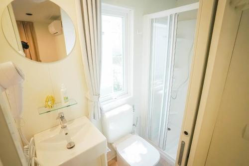a white bathroom with a sink and a mirror at Happy Camp mobile homes in Camping Village Free Time in Marina di Bibbona