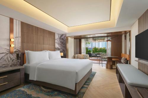 a hotel room with a bed and a television at Sari Pacific Jakarta, Autograph Collection in Jakarta
