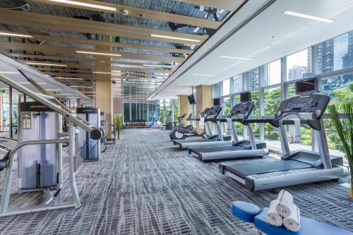 un gimnasio con cintas de correr y máquinas elípticas en Savills Residence Daxin Shenzhen Bay, en Shenzhen