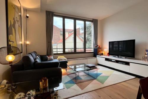 アニエール・シュル・セーヌにあるBright accommodation in Asnières-sur-Seineのソファとテレビのあるリビングルーム
