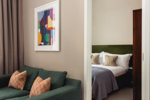 a bedroom with a bed and a green couch at Native Hyde Park in London